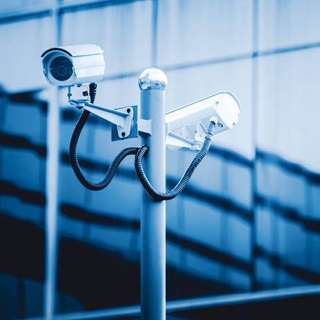 surveillance camera front of modern building,blue toned.