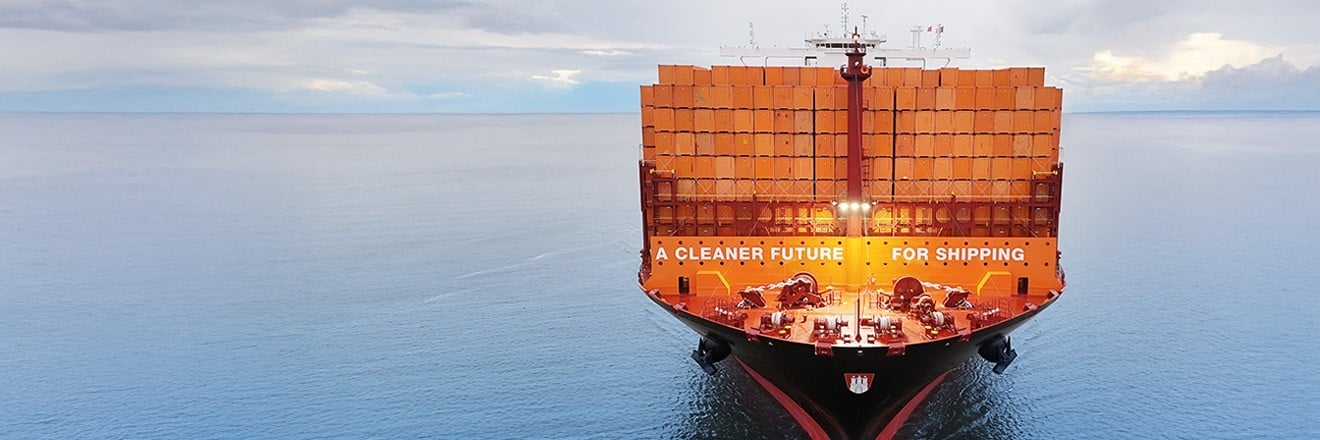 Quick Quotes Spot with Hapag-Lloyd. A person is typing something on a computer from Hapag-Lloyd. The front of the picture is characterized with a calendar and orange arrows as well as ship icons.