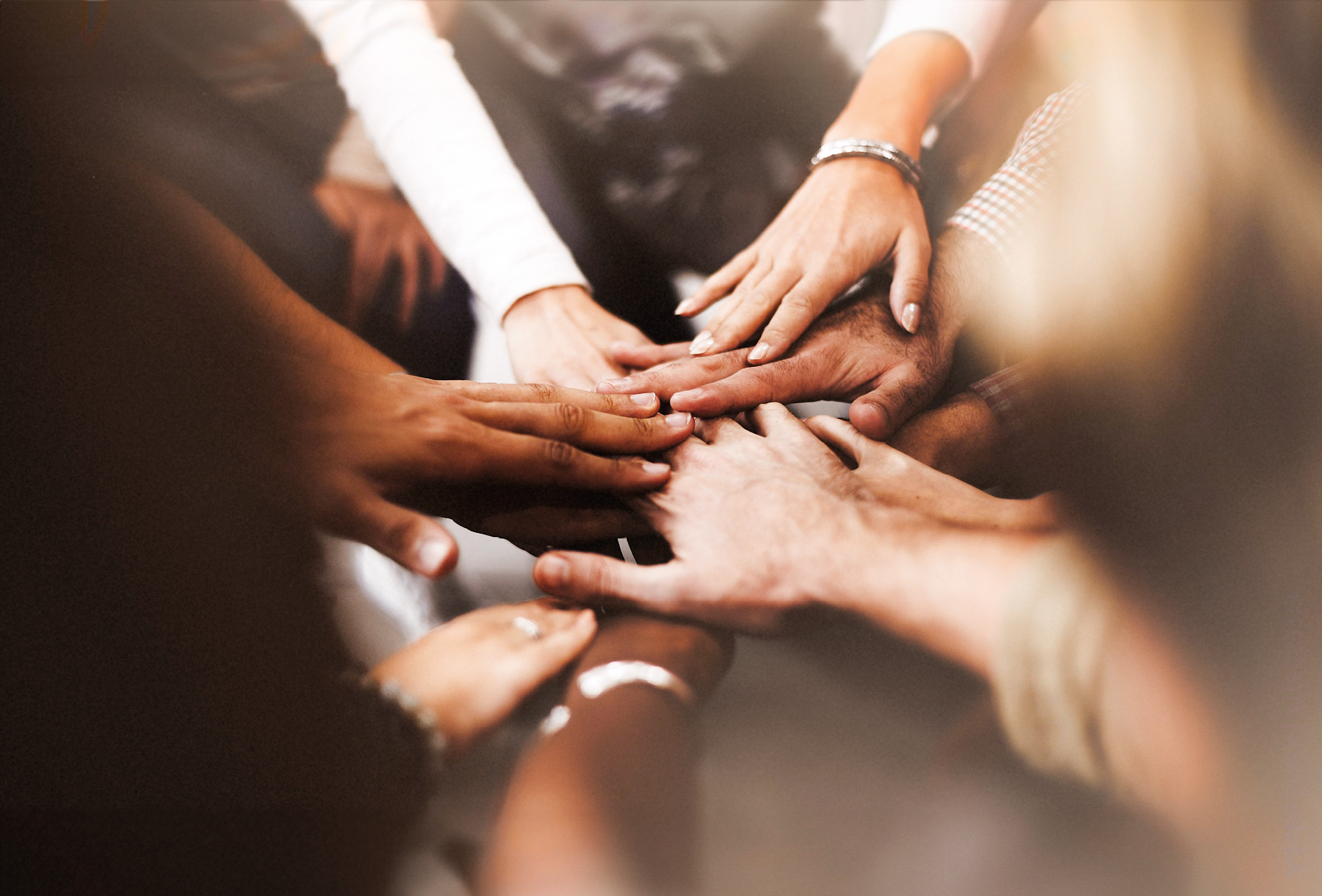 Closeup of diverse people joining their hands